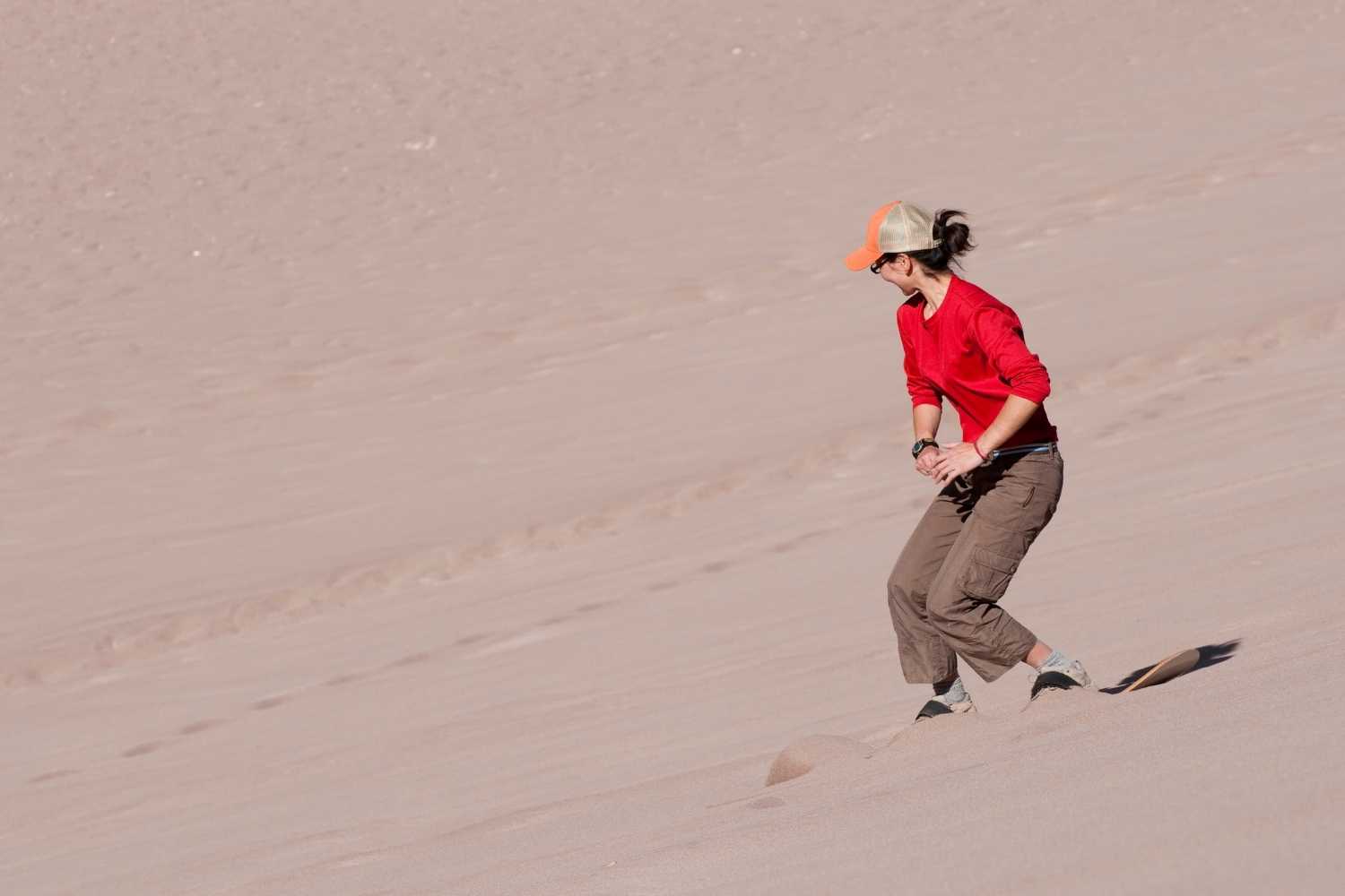 Sandboarding down desert dunes